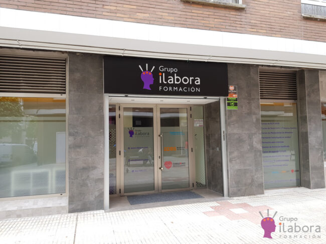 Aula de formación moderna equipada con mesas, sillas, pizarra y recursos para el aprendizaje presencial.